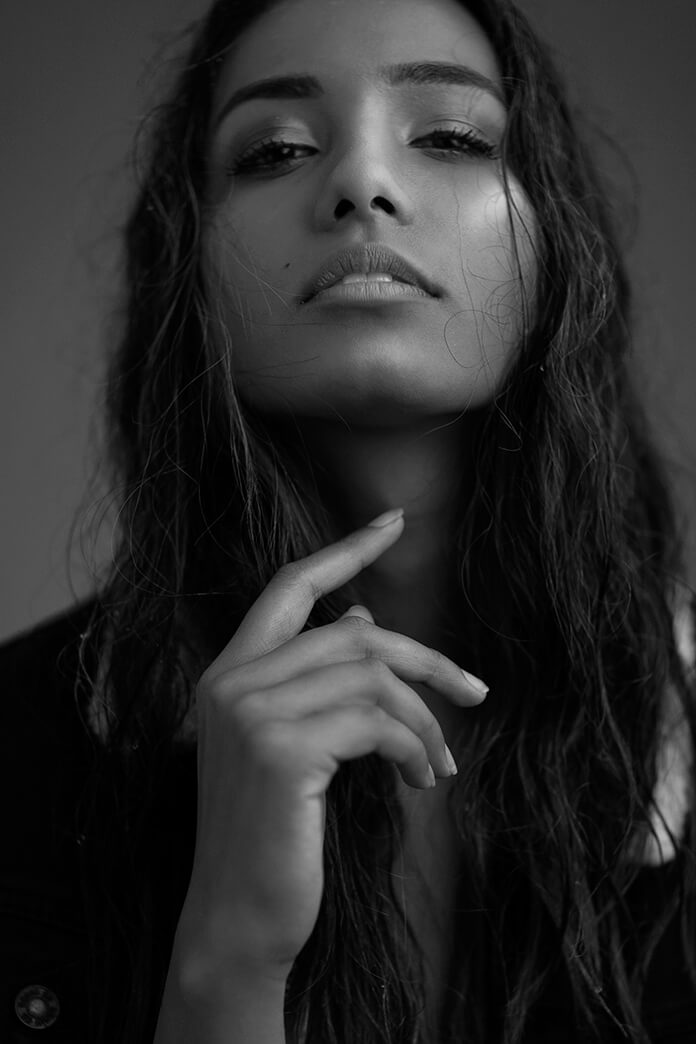 Black and white photo of commercial model posing for the camera with makeup by Bristol makeup artist Evie Smith