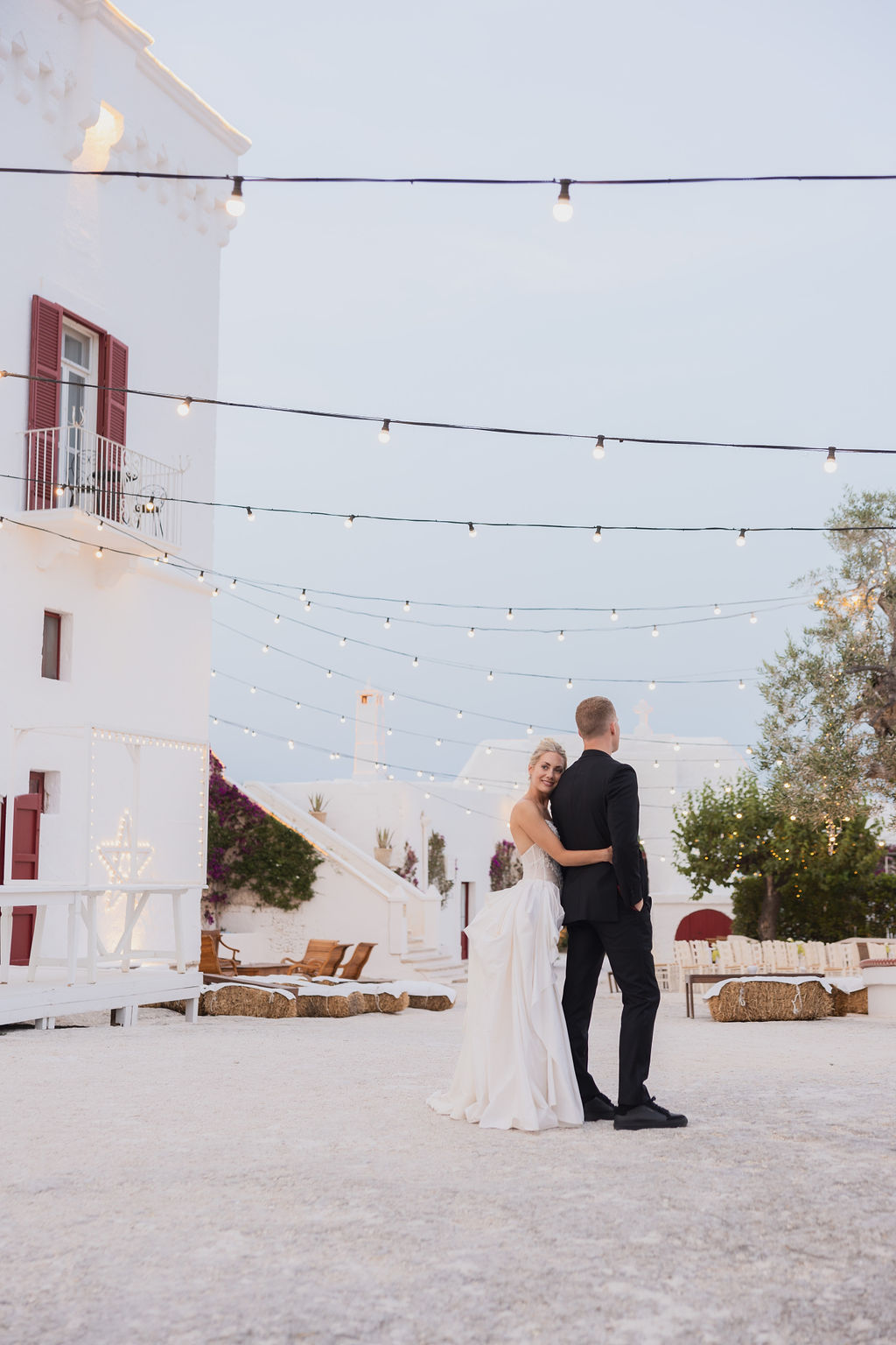bride and groom at their destination wedding in italy. the bride is looking back at the camera wearing a white dress and her hair in a high bun