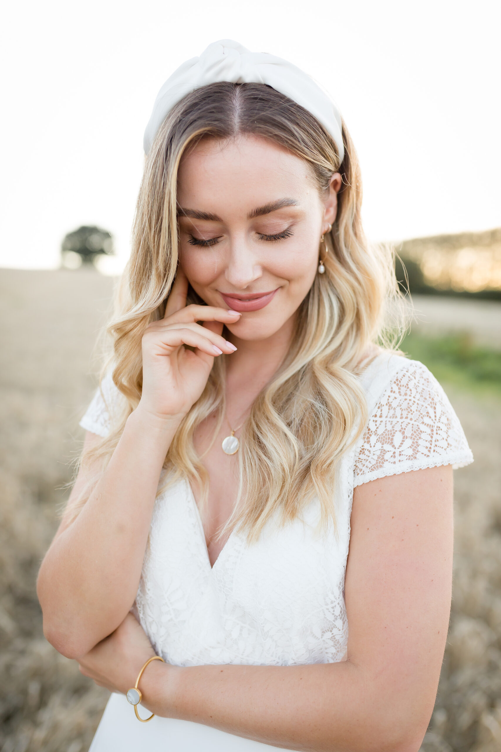 Bride looking down smiling with makeup by Bristol makeup artist Evie Smith.