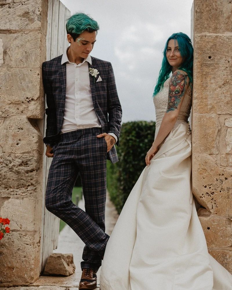 Destination wedding bride and groom standing together in a stone archway on location in Sicily.