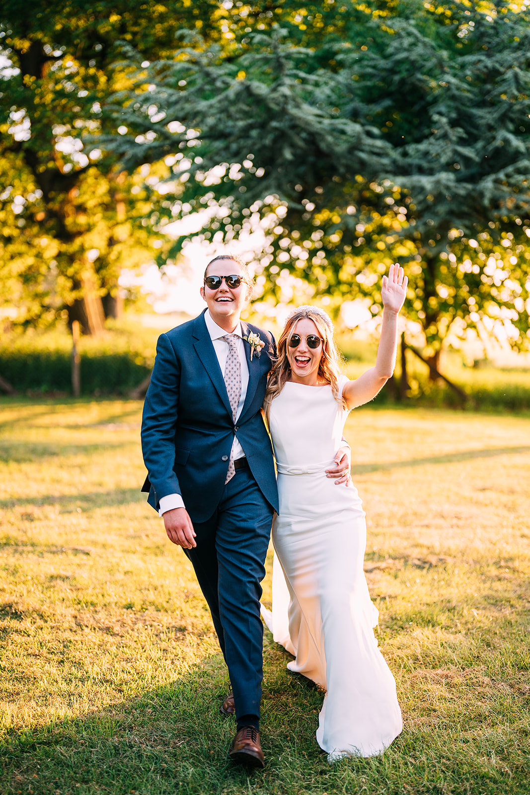 same-sex couple Holly and Liv on their wedding day in Coombe Lodge. bride is wearing white and another bride is wearing a blue suit with a pink tie